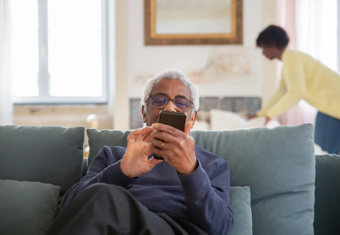 An older adult confidently using a smartphone at home