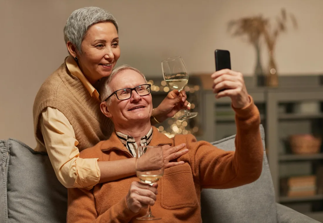 Older adults happily taking a photo together with a smartphone